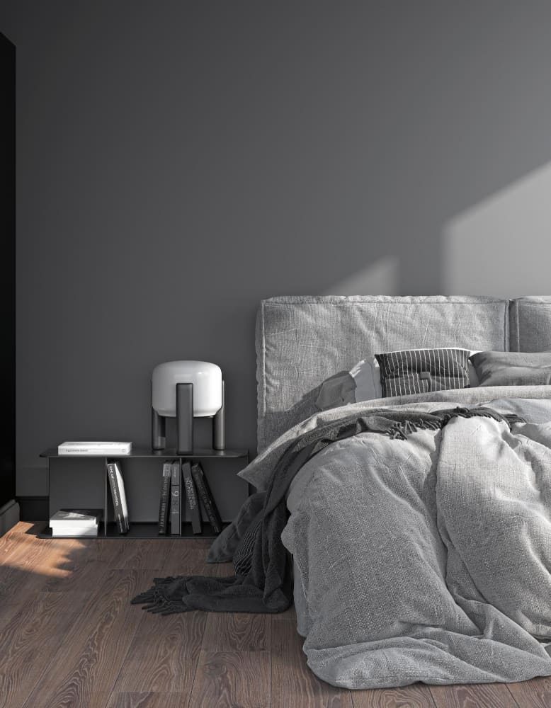 un lit défait dans les tons gris avec un parquet au sol et une table de nuit moderne