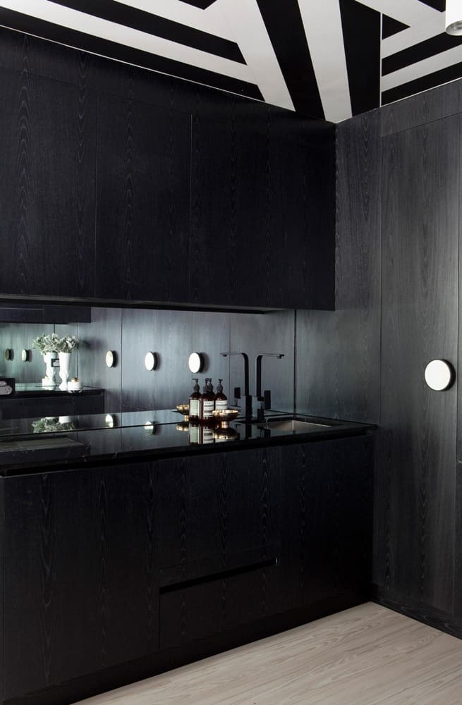 un plafond noir et blanc et un sol en parquet clair mettent en valeur les meubles noir mat