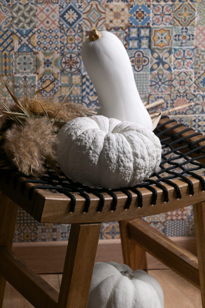 un tabouret fait main unique et original devant un mur moderne imitation carreaux de ciment