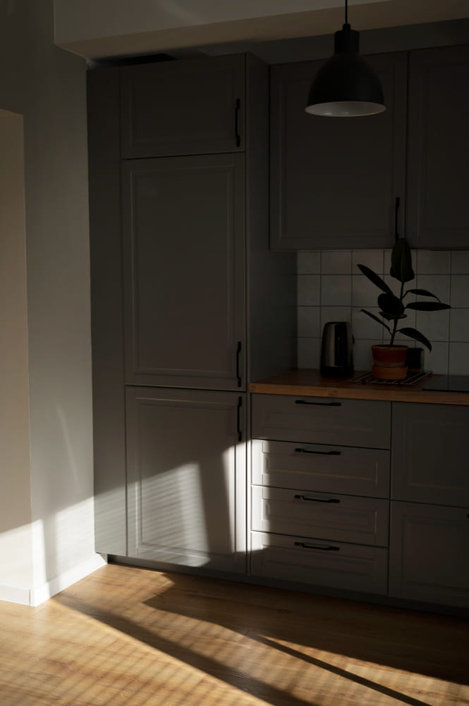 la tendance couleur cuisine 2026 est ici au gris anthracite sur les façades des meubles, avec un sol en parquet