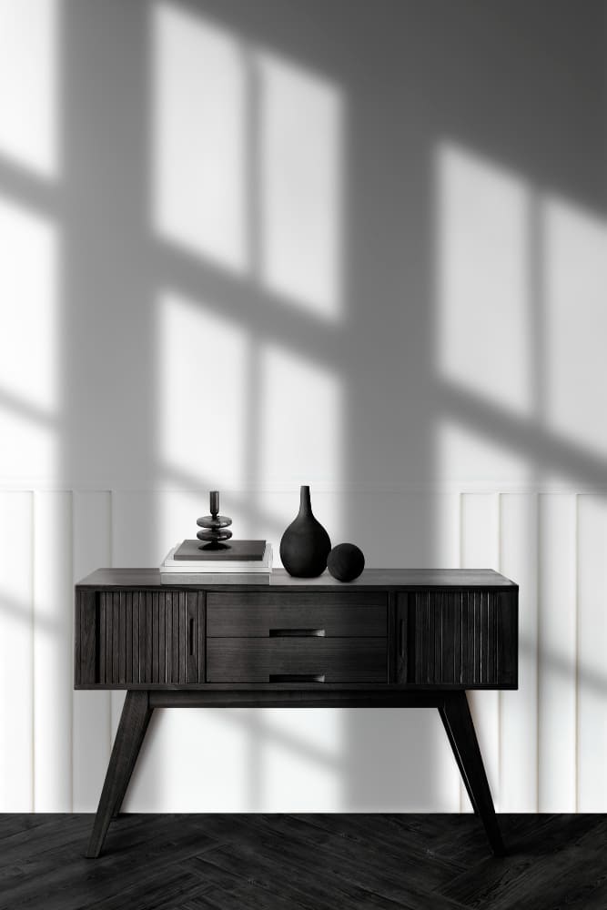 tendance déco 2026 avec des contrastes dans la pièce : un meuble de style scandinave noir devant un mur blanc