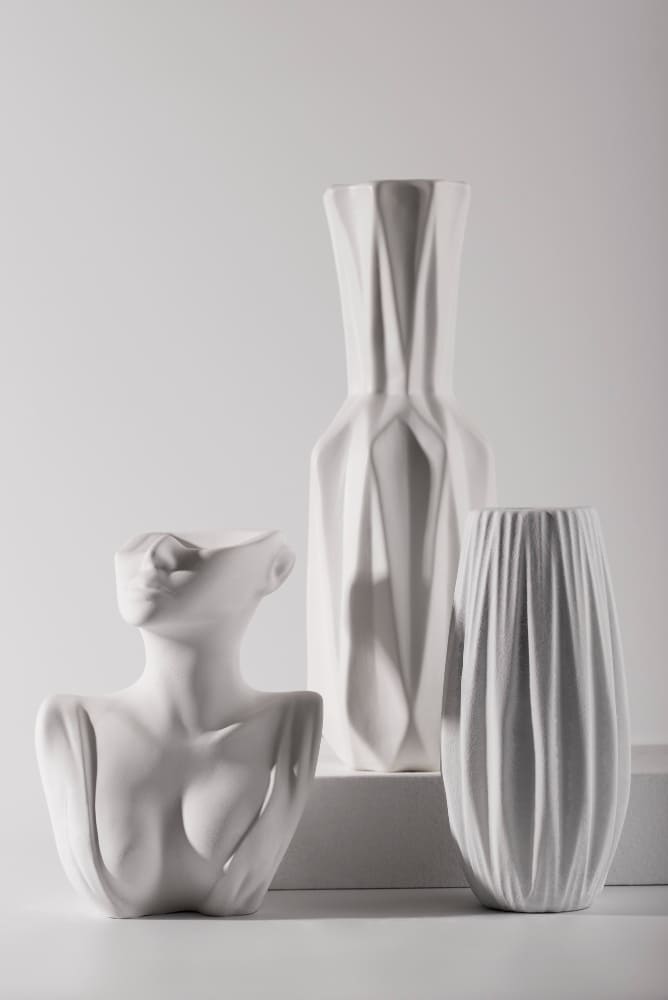 trois vases blancs de différentes tailles et de formes sculpturales