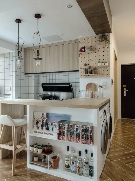 Aménagement petite cuisine 6m2 en bois avec îlot multifonction, tabouret, étagères et rangements intégrés.