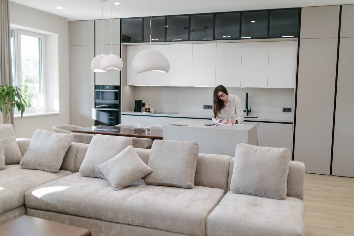 Cuisine ouverte sur salon 20m2 avec îlot central, suspensions blanches, grandes armoire et canapé beige