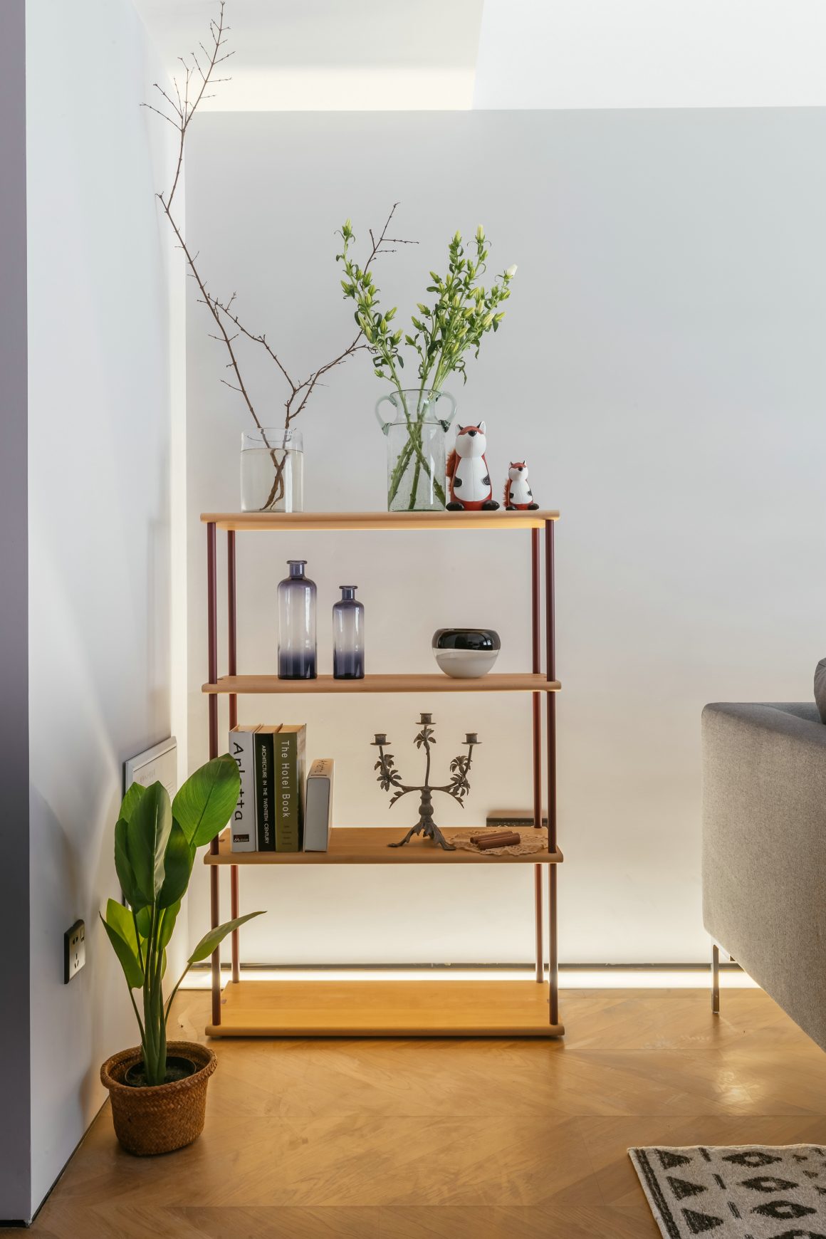 Étagère minimaliste en bois avec plantes, objets décoratifs et livres