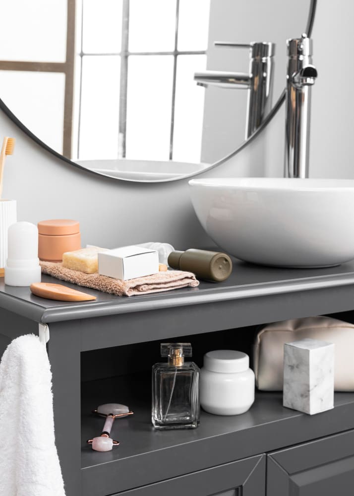un meuble vasque peint en gris ancien rénové avec une vasque en céramique blanche et un miroir rond