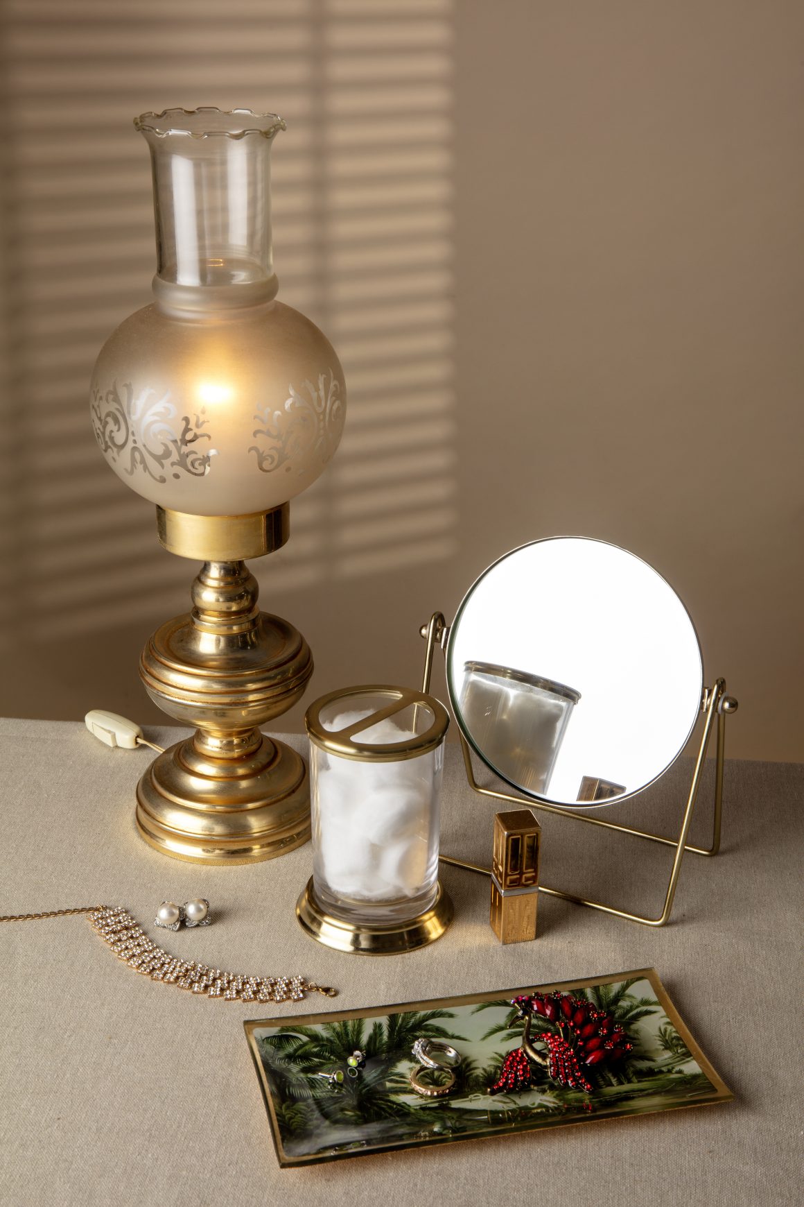 Luminaires dorés, miroir, bijoux et photo: ambiance vintage chic avec touches lumineuses et élégantes.