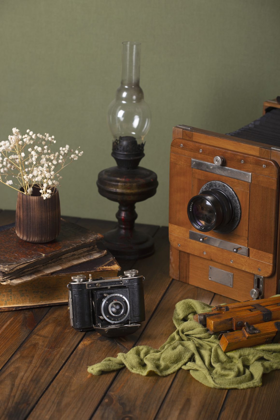 Objets déco vintage : vieil appareil photo, caméra antique, livres et lampe à pétrole