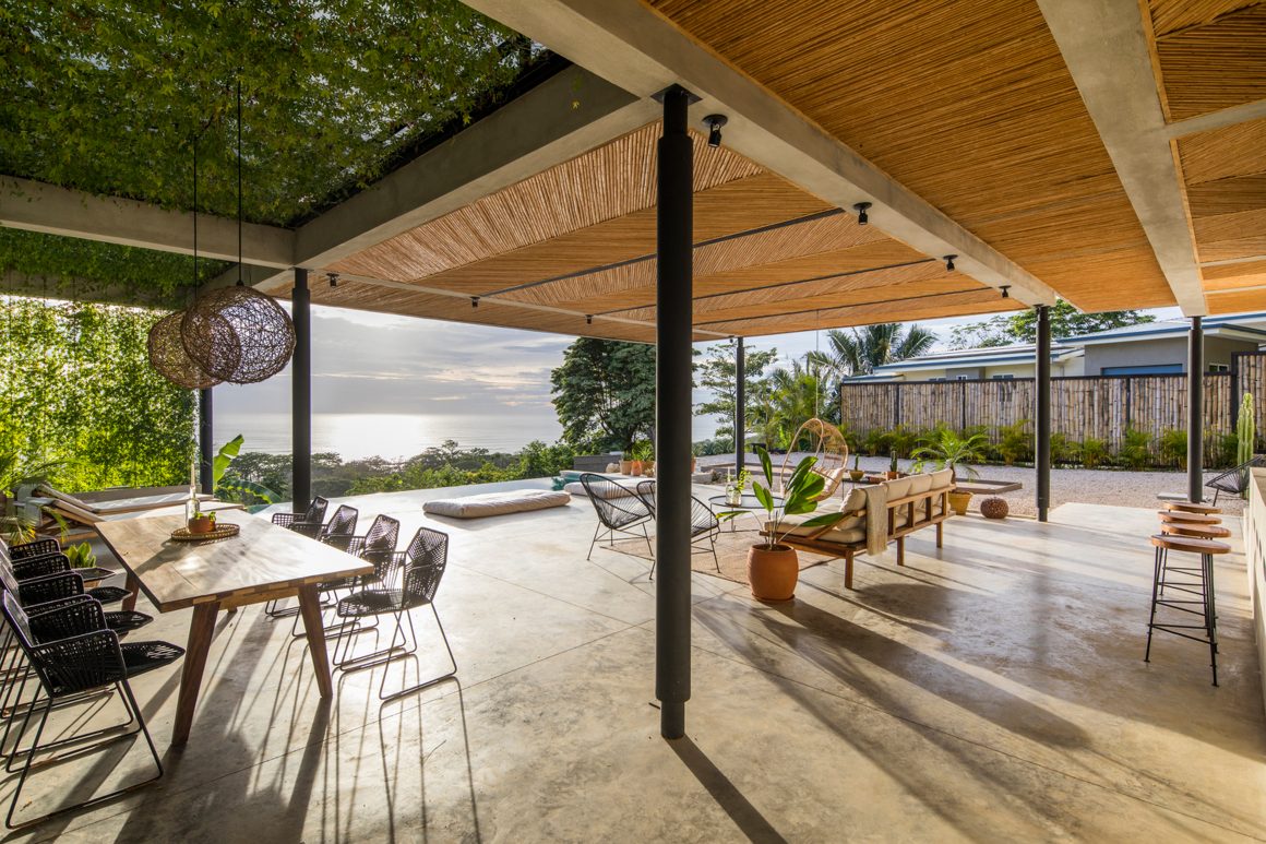 Extérieur avec pergola dont l'ombrage est en canisse naturelle tressée et un toit partiellement couvert par treillis végétal de l'autre côté.
