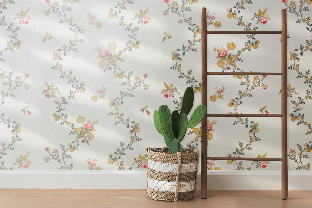 du papier peint tendance 2026 orné de motifs symétriques, avec des feuilles et des fleurs, et un cactus en pot devant