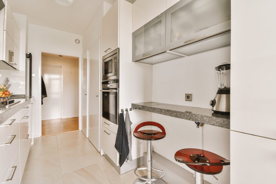Aménagement petite cuisine 6m2 avec rangements, petit coin repas, tabourets et appareils encastrés