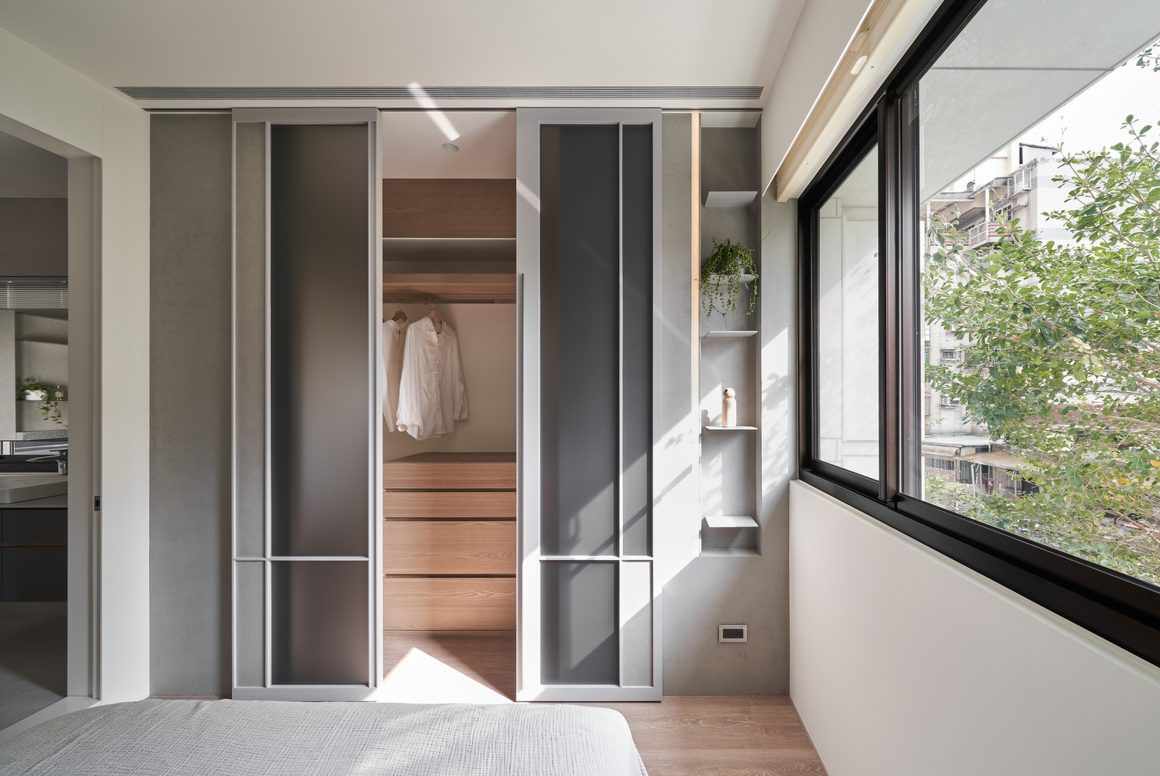 Chambre incluant un placard coulissant minimaliste en bois clair, grande fenêtre et lit