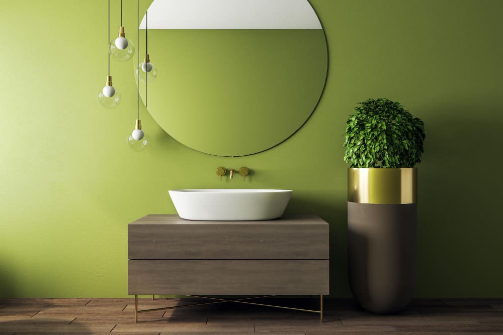 une salle d'eau minimaliste avec un miroir fond au-dessus du meuble vasque, avec un lavabo blanc et une plante sur la commode