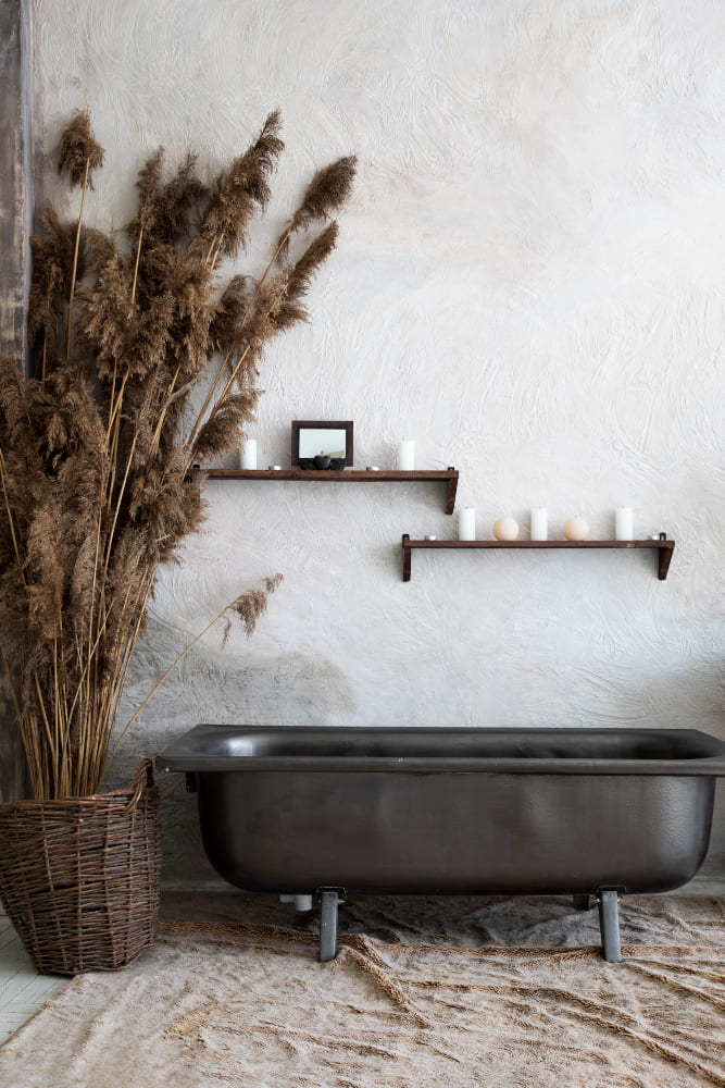 Dans cette pièce, les tendances salle de bain se tournent vers une baignoire ancienne et des paniers en osier déco sur les étagères au mur