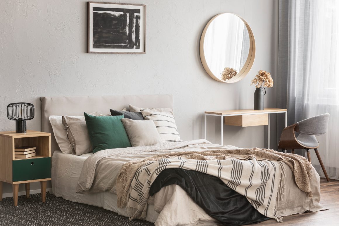 Chambre moderne et douce: avec lit beige, meubles en bois clair, tapis et miroir rond