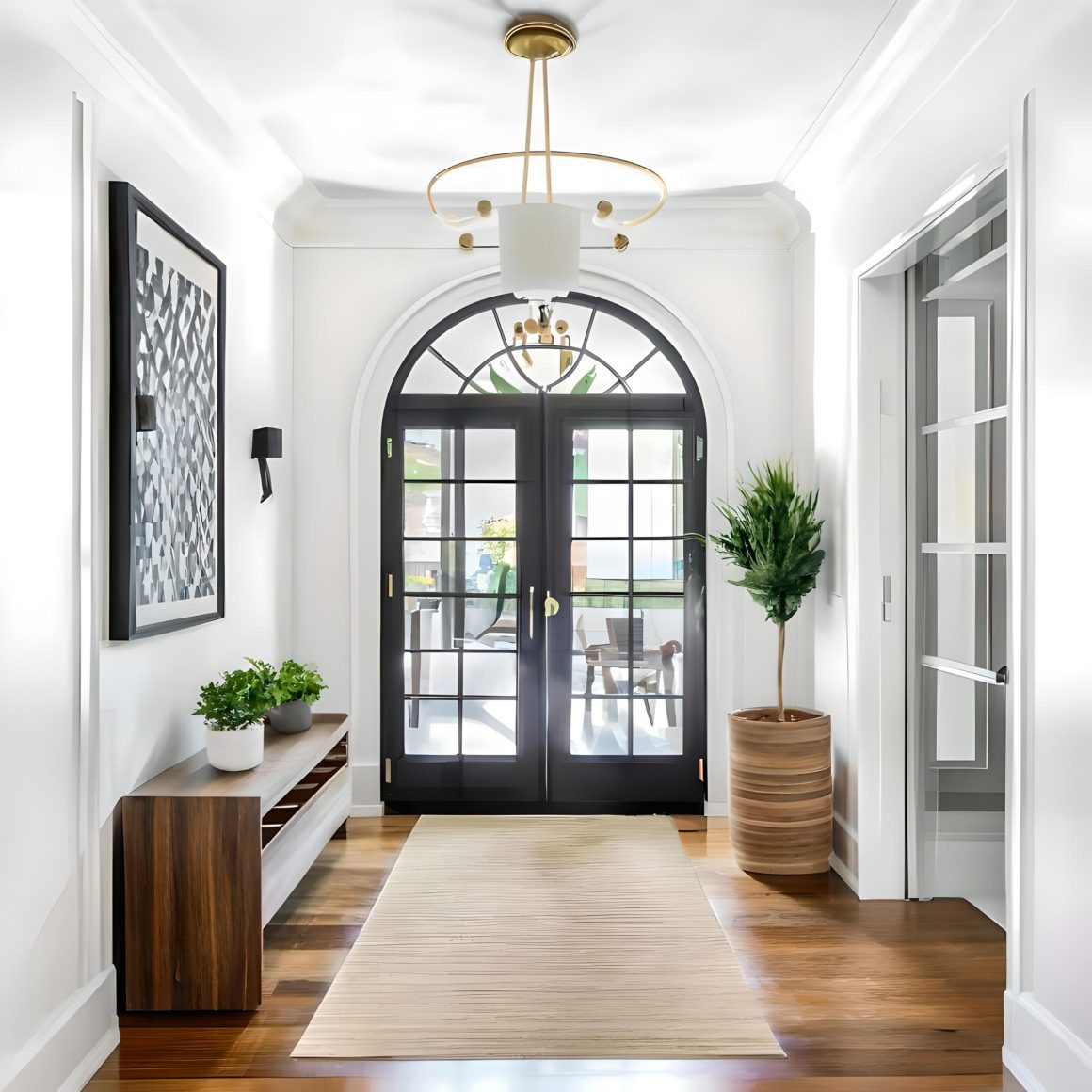 Entrée lumineuse et élégante avec plante en pot, suspension dorée et tapis