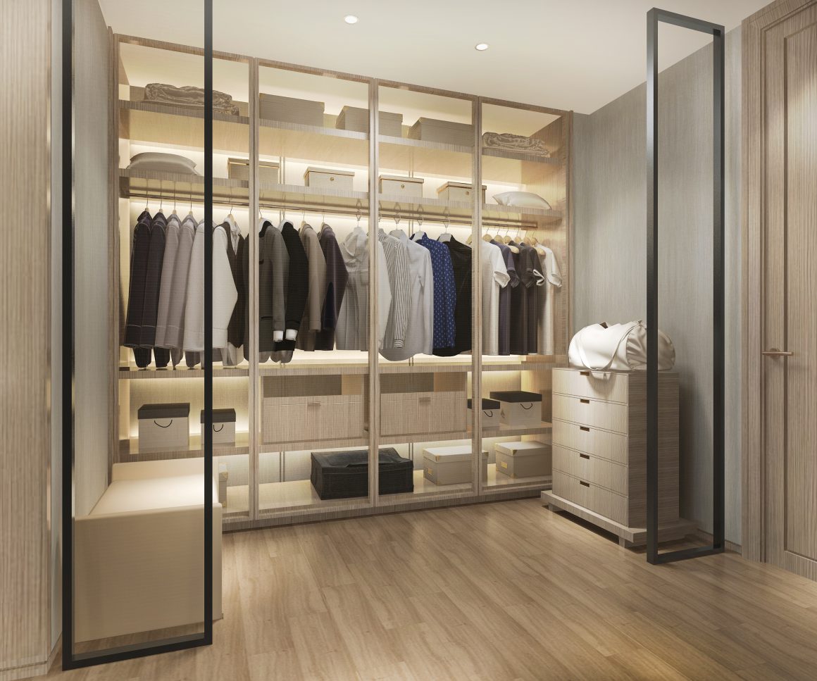 Dressing walk-in lumineux en bois clair avec penderies, casiers, boîtes et tiroirs