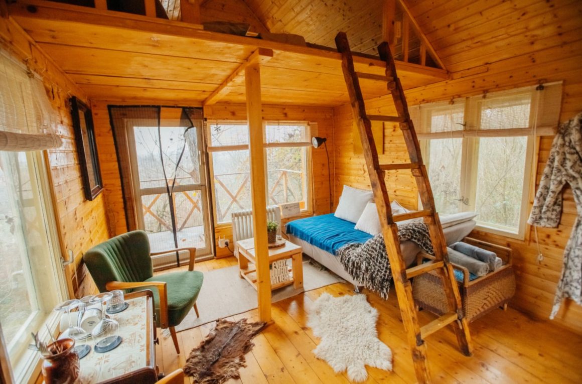 Cabane en bois incluant lit double en mezzanine, échelle, salon cosy, tapis fourrure et coin détente