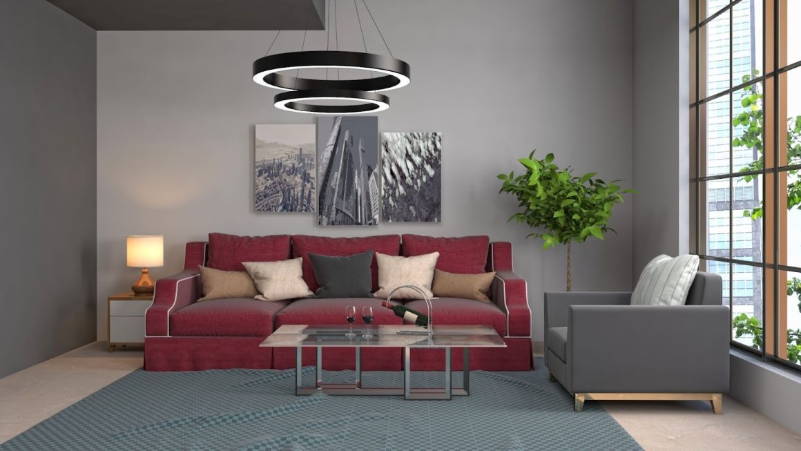 Salon lumineux avec murs gris, canapé rouge, fauteuil gris, table basse en verre, suspension, tapis et plante