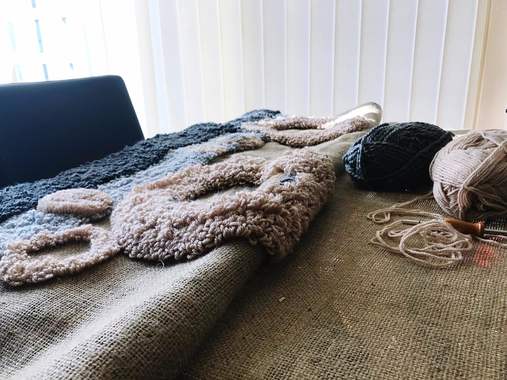 confection d'un tapis moelleux et texturé, avec les outils de travail posés à côté