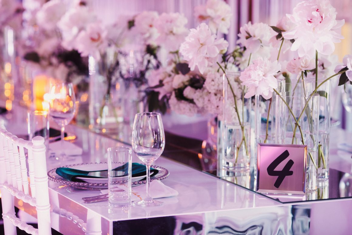Table élégante décorée de fleurs roses, vaisselle raffinée et verres scintillants