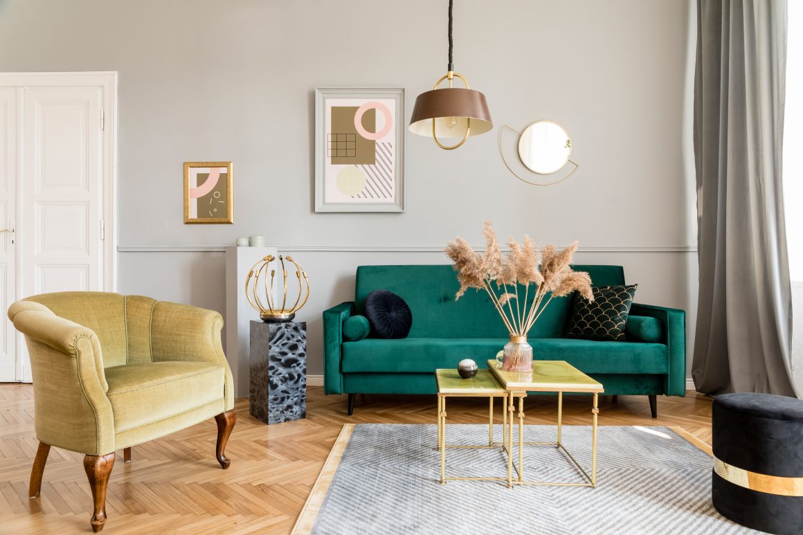Décoration d'un salon cosy incluant canapé vert et fauteuil jaune avec miroir, tableaux, fleurs séchées et tapis