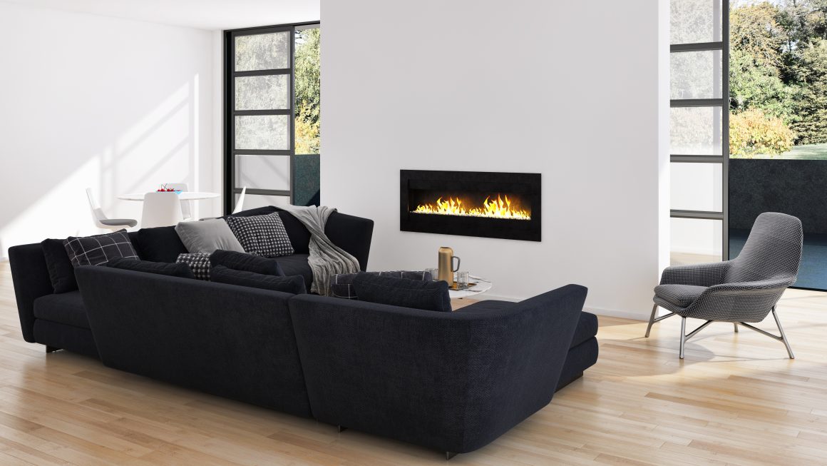 Salon moderne avec canapé d'angle noir, fauteuil, cheminée bio encastrée et grandes baies vitrées donnant sur verdure.