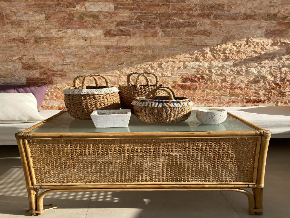 une table en osier avec des paniers en matières naturelles de différentes tailles