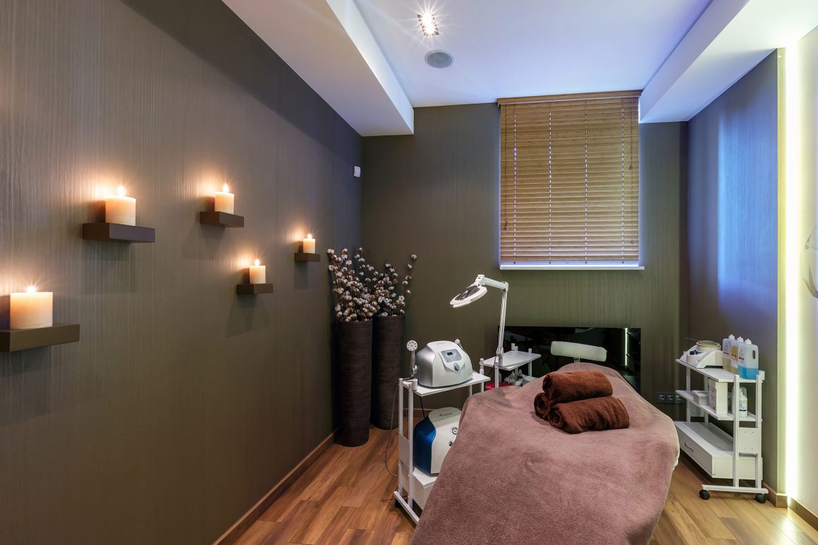 Cabine esthétique aménagée avec table de massage, bougies, appareils et éclairage doux
