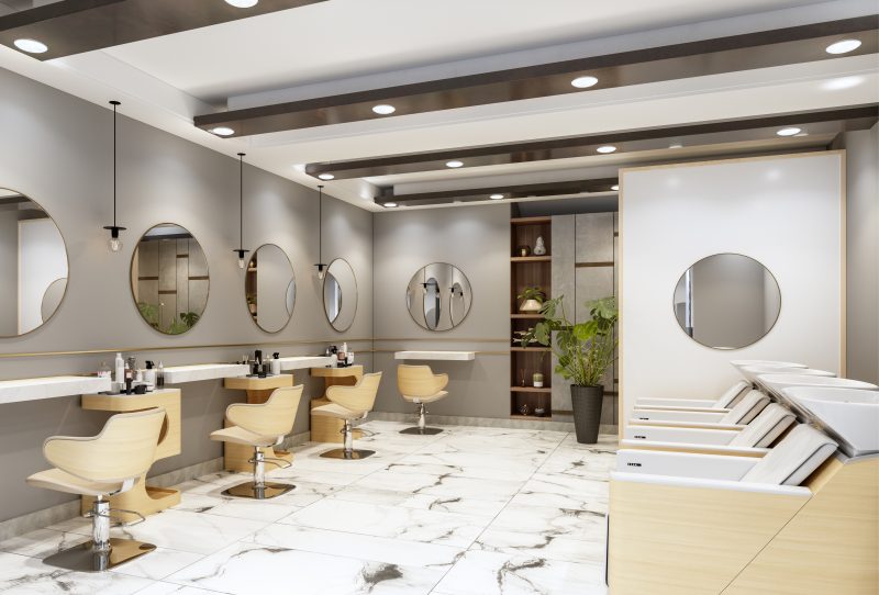 Agencement salon de coiffure avec fauteuils en bois, miroirs ronds, lavabos alignés et déco épurée