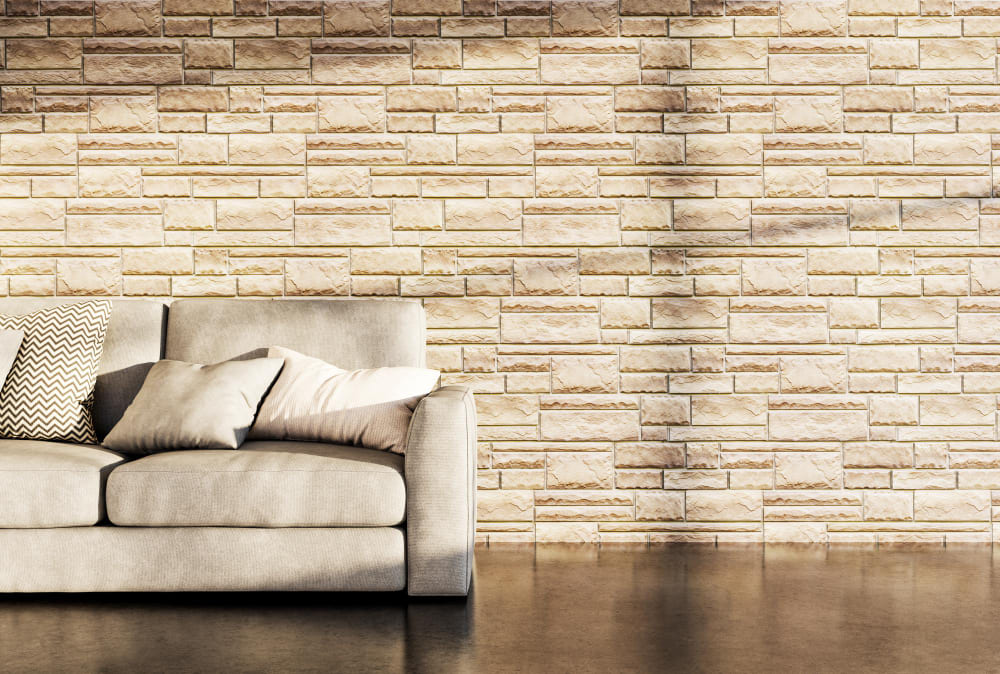 une décoration murale dans le salon tendance, avec un canapé gris et un coussin confortable devant un mur en pierre