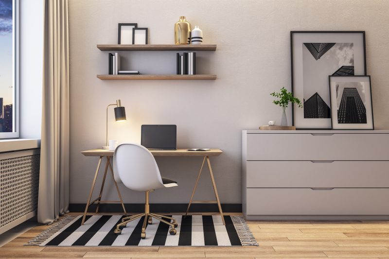 Espace de travail moderne avec chaise blanche, bureau en bois, lampe, étagères, commode grise et tapis