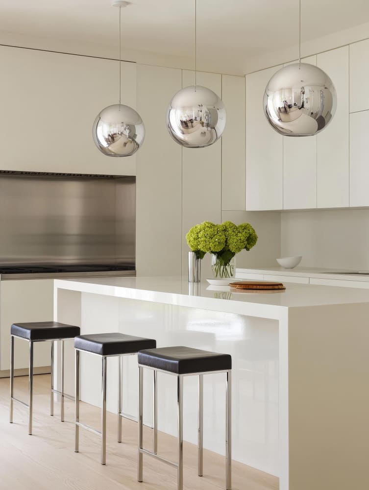 une grande cuisine minimaliste gris perle, avec un îlot central et des tabourets de bar