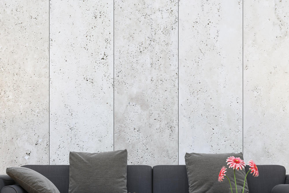 de grandes dalles de granit en guise de mur derrière un canapé gris