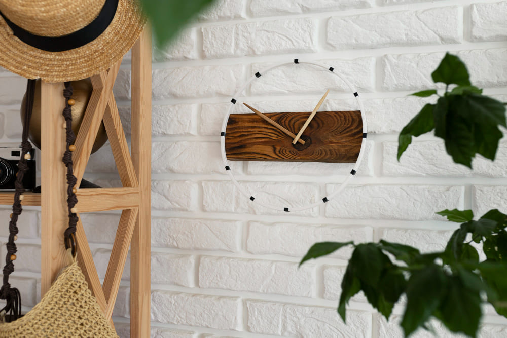 une horloge murale en bois fait main, accrochée sur un carrelage métro