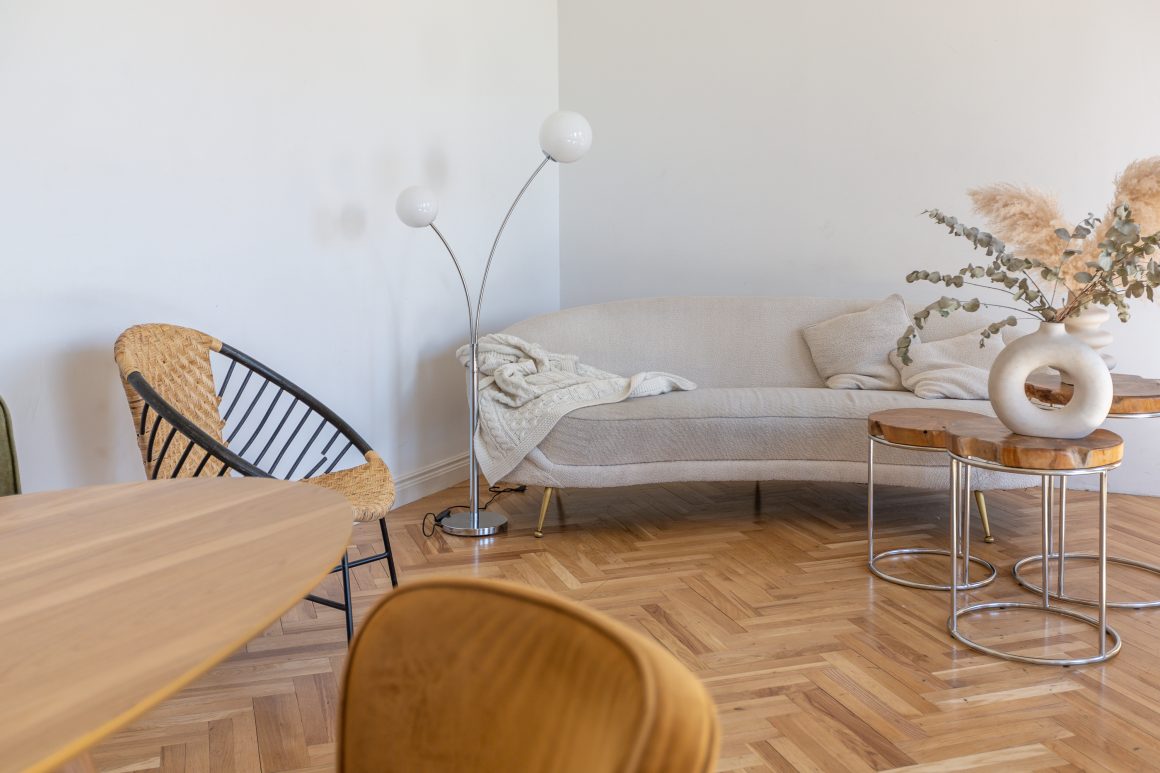 Pièce de vie au design scandinave avec table en bois clair, canapé beige, luminaires et touches naturelles.