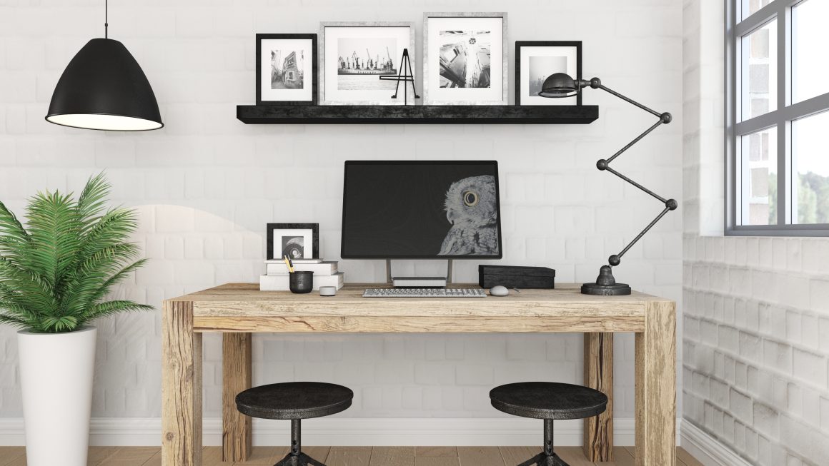 Bureau minimaliste en bois clair avec ordinateur, lampes, plantes, cadres muraux et tabourets noirs
