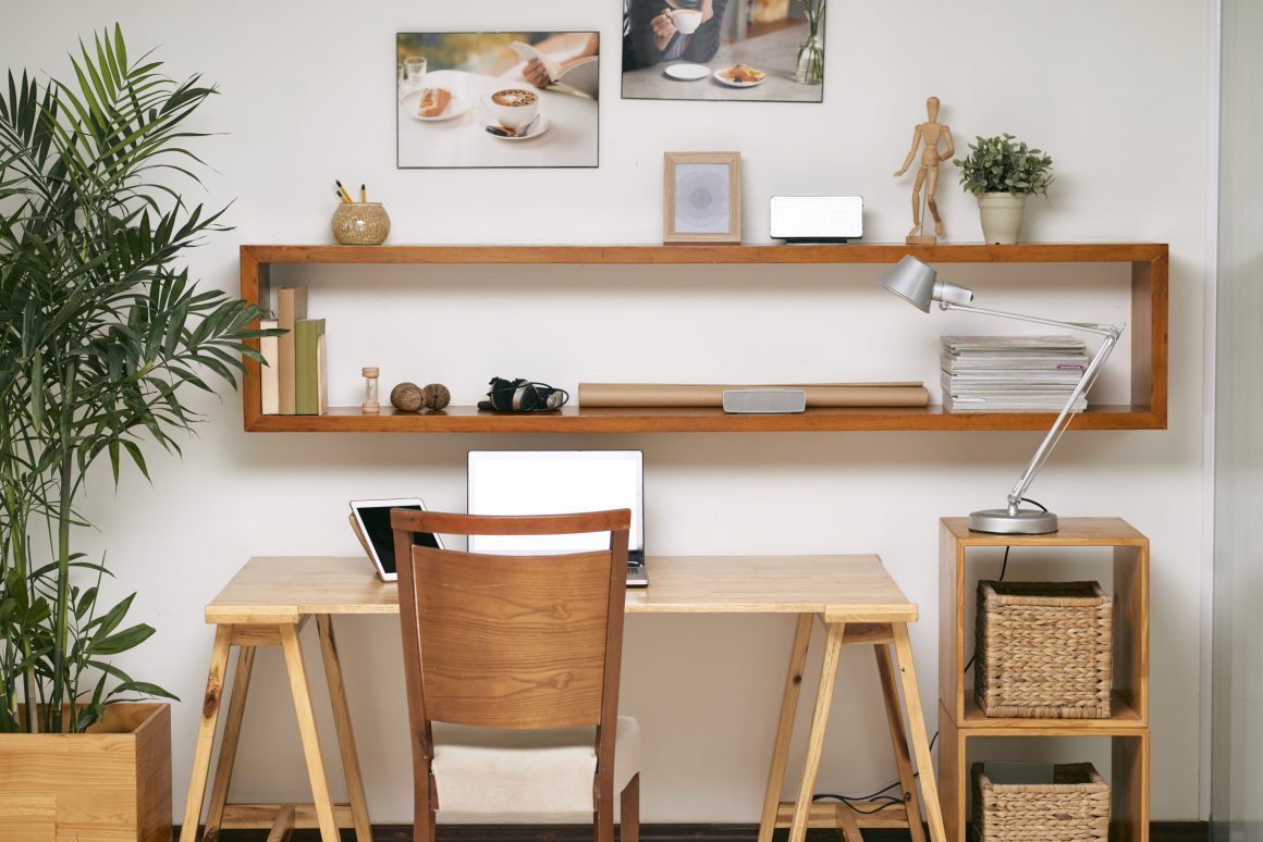 Bureau en bois avec lampe, étagères, plantes et paniers tressés