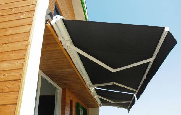 Store banne rétractable noir fixé à une maison en bois