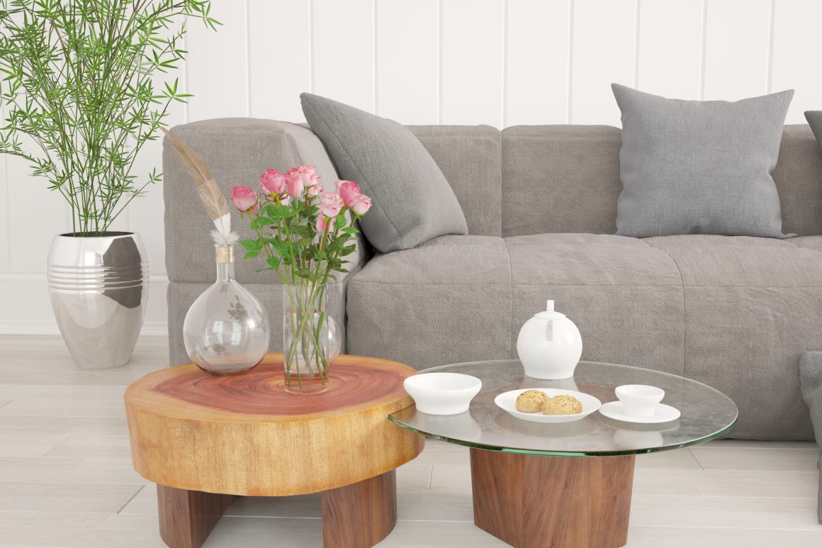 Canapé gris et table basse en bois et verre incluant tasses blanches et vase