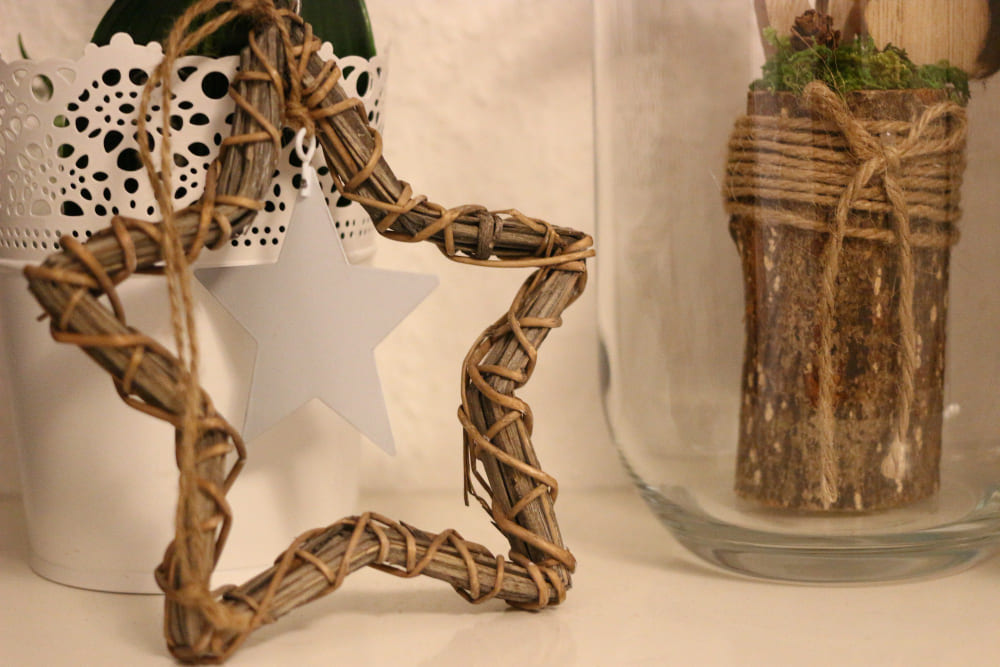 tendances déco dans une maison moderne avec une étoile DIY en bois et un bocal en vert derrière avec des décos en bois