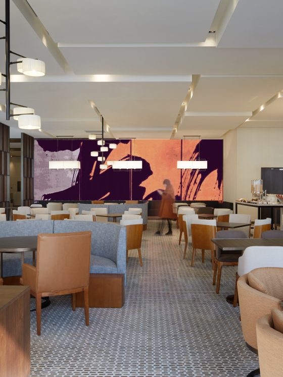 Restaurant incluant mobilier chaleureux en cuir et tissus et grandes œuvres murales