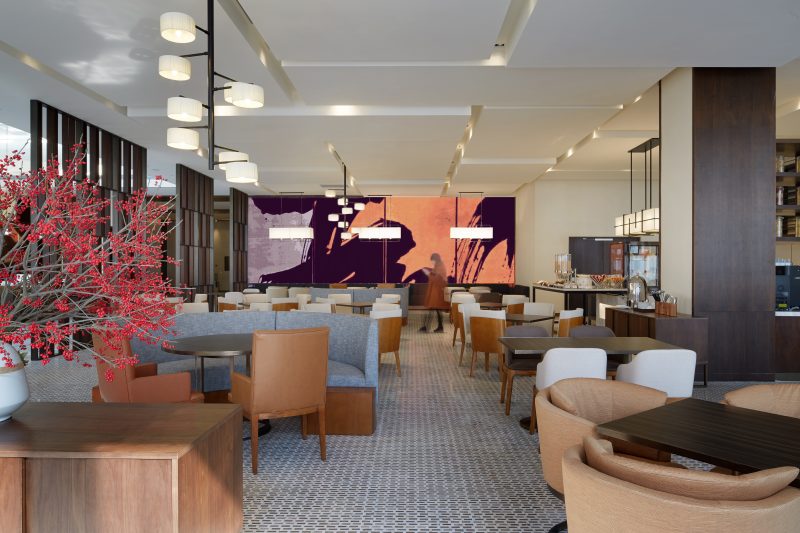 Restaurant incluant mobilier chaleureux en cuir et tissus et grandes œuvres murales