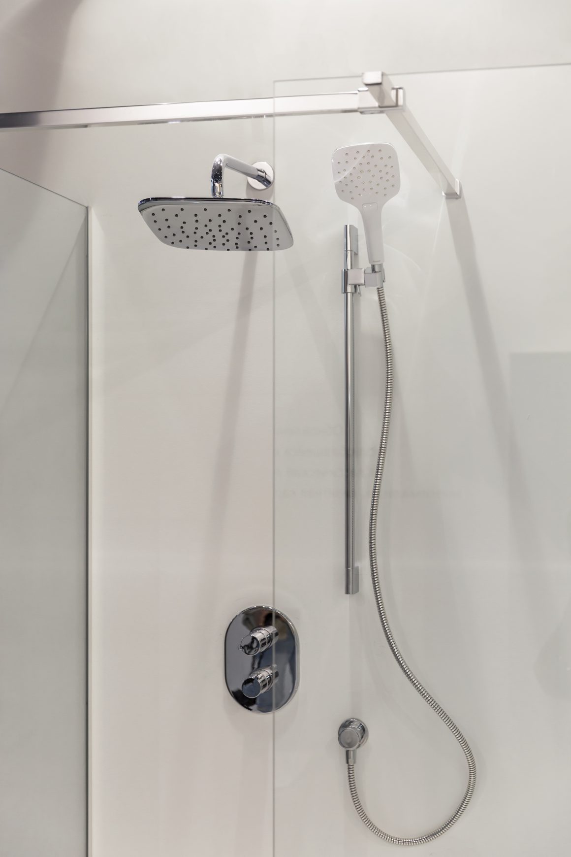 Douche moderne en verre, pommeau plafond et douchette chromée élégante