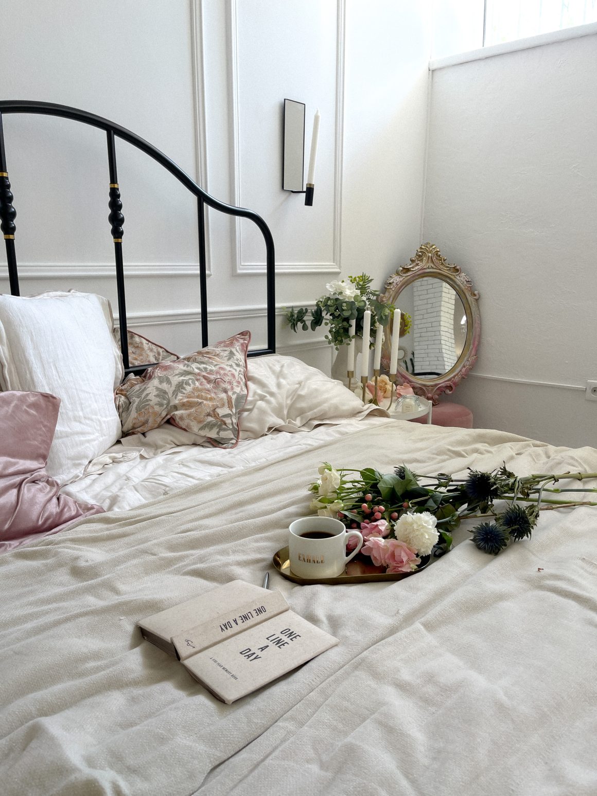Déco chambre romantique chic avec fleurs, coussins pastel, miroir doré et bougies