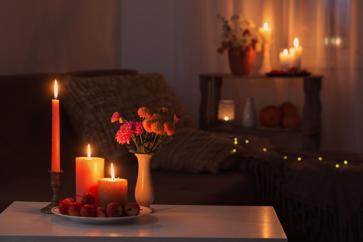 Ambiance chaleureuse dans une chambre avec bougies allumées, fleurs et lumière douce