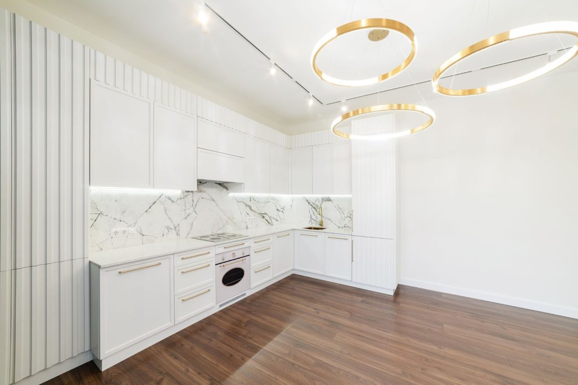 cuisine blanche incroyablement tendance, combinee avec du marbre blanc et un revetement au sol en bois