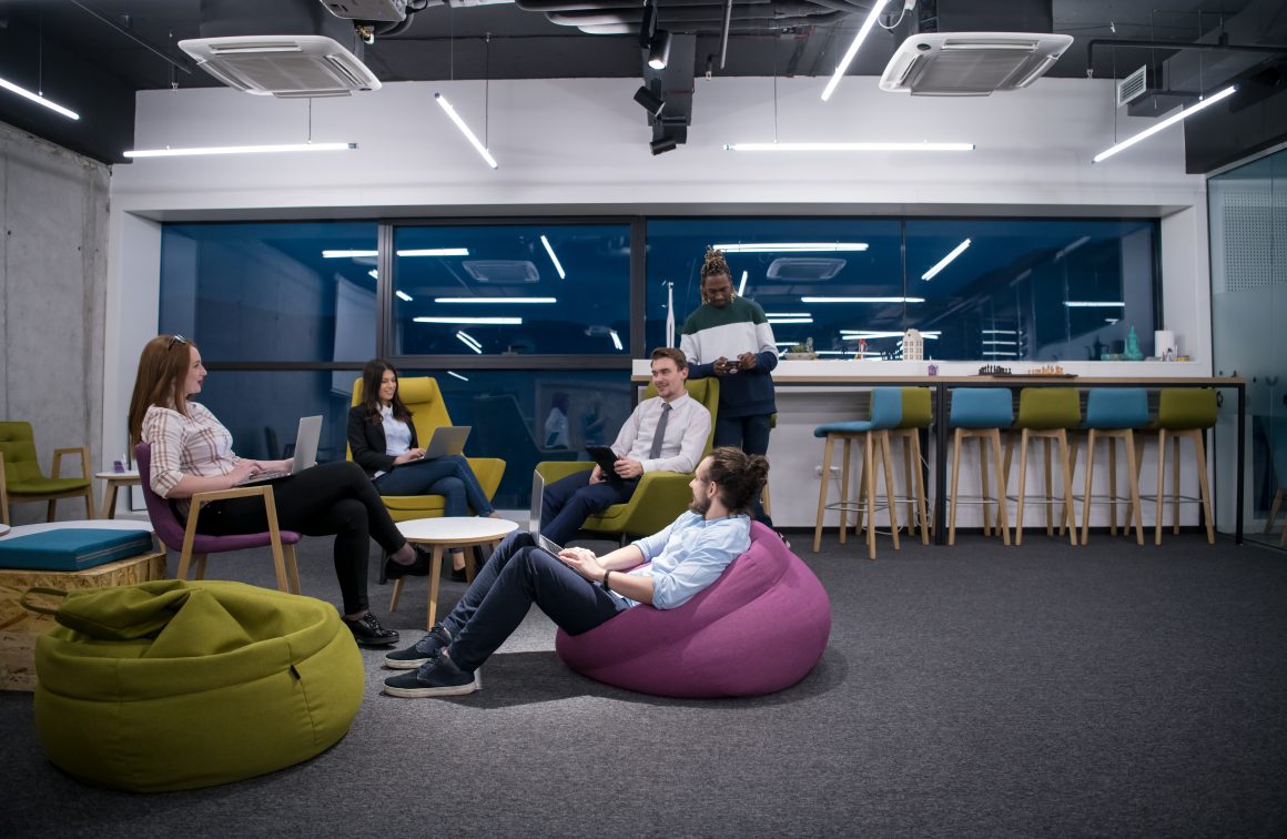 Groupe de personnes dans un espace détente lumineux avec sièges colorés
