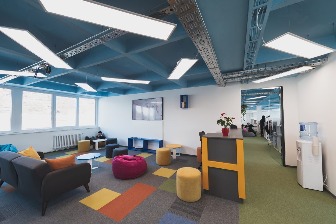 Salle de pause entreprise aménagée avec canapé, poufs, beanbag et tables basses