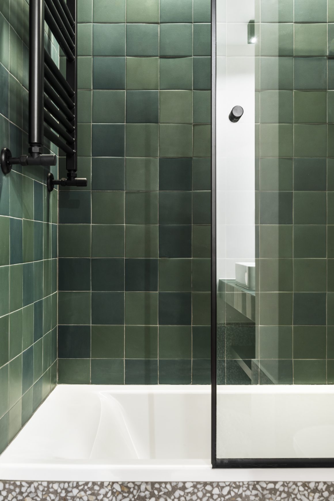 Carrelage de salle de bain vert émeraude, baignoire vitrée et porte-serviette